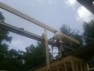 Carpenter setting a ridge beam over a new addition frame — Ice Dam Removal by Roofing Brothers in Le Mars
