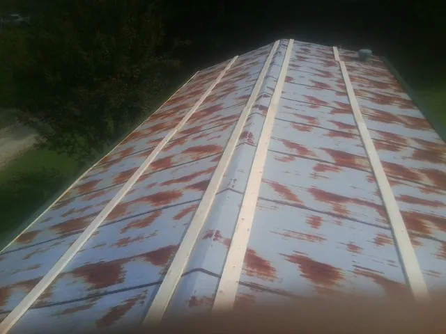 Rusted metal roof panels with new wood purlins before replacement — Storm Damage Roof Repair in Le Mars by Roofing Brothers